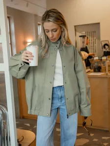 Gedetailleerde weergave van losse groene katoenen werkjas voor dames in een café