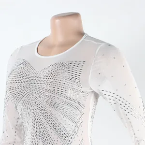 Close-up of white sheer mesh dress with intricate silver rhinestone embellishments
