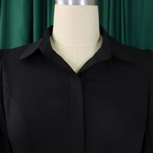 Primer plano detallado de un elegante vestido negro con cuello de camisa para mujer en maniquí.