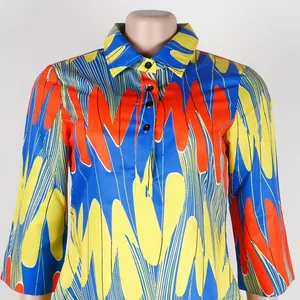 Close-up detail of slim fit dress with vibrant blue and yellow geometric pattern and lapel