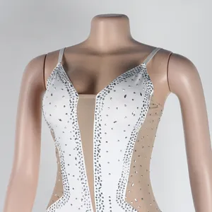 Detail view of a white bodysuit featuring sheer mesh panels and sparkling rhinestones.