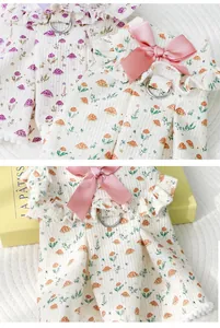 Macro view of pet dog dress featuring mushroom print, pink bow, and D-ring for leash attachment