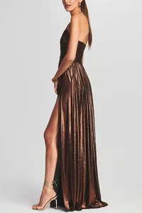 Detail shot of a bronze metallic strapless pleated maxi dress with a high slit