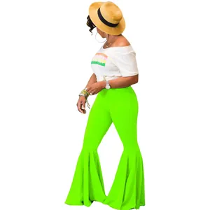 Vista detallada de los pantalones acampanados verde neón con volantes y corte ajustado