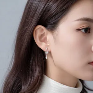 Elegant silver titanium alloy star and moon cartilage stud earring shown on an Asian model