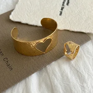 Vue détaillée d'une parure en acier doré 18 carats avec motif cœur et texture martelée