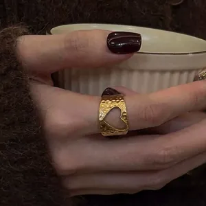 Gros plan d'une bague en acier titane plaqué or 18K avec texture martelée et cœur évidé