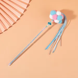 Macro view of fairy cat teaser wand with glitter handle and colorful pompom cluster.