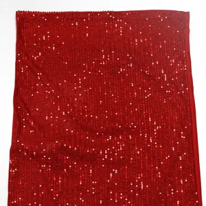 Gros plan sur la texture du tissu à paillettes rouges scintillantes d'une robe de soirée