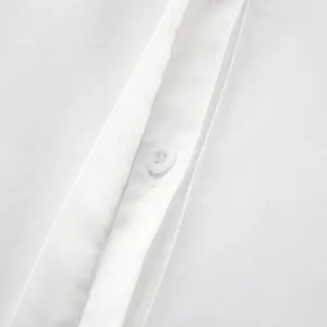 Primo piano di un'abbottonatura di camicia bianca in cotone con cuciture rifinite