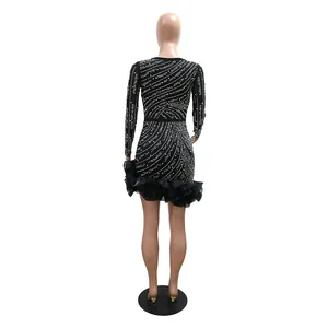 Back view of black long-sleeve mini dress with rhinestone patterns and ruffled hem.