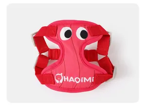 Gros plan d'un harnais rouge pour chien avec de grands yeux et le logo HAQiMi imprimé.