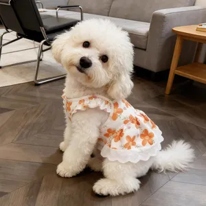 Detailed view of small dog wearing a breathable orange floral summer dress with elegant lace trim