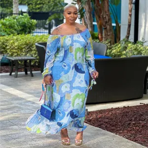 Stylish model wearing a blue floral off-the-shoulder maxi dress in an outdoor garden setting