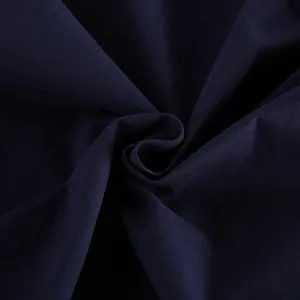 Close-up van donkerblauwe katoenen stof met twill-weving en textuur voor een jasje.