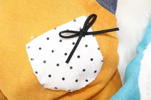Macro detail of pet winter clothes showing white polka dot pocket with black bow