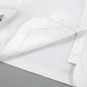 Dettaglio ravvicinato delle cuciture fini e del bottone su una camicia bianca.