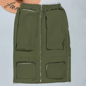 Detailed view of army green cargo skirt featuring functional zipper pockets and elastic waist