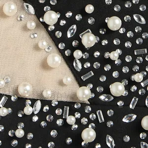 Dettaglio macro di strass scintillanti e perle su tessuto di tuta in mesh sexy ed elegante