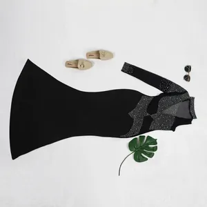 Elegante vestido ajustado negro de manga larga con detalles de pedrería y malla fina
