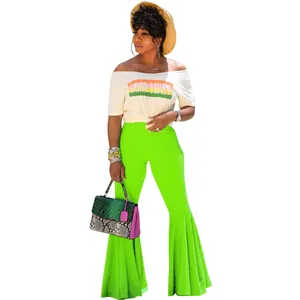 Pantalones de campana con volantes verde neón y camiseta blanca con eslogan sexy.