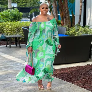 A detailed view of a woman wearing an off-the-shoulder green floral maxi dress in garden
