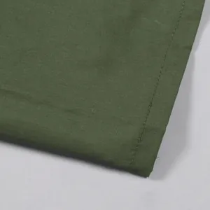Macro detail of the olive green cargo skirt's hem showing very precise stitching