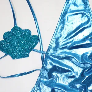 Detailopname van een metallic blauw badpak met een glinsterend schelpvormig detail