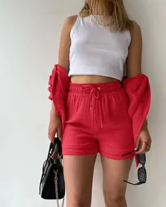 Lässiges rotes zweiteiliges Damen-Set aus Crinkle-Stoff mit Shorts und lockerer Bluse.
