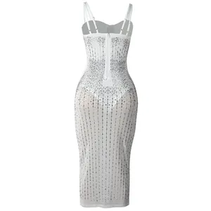Vista posteriore di un abito bianco trasparente aderente con strass verticali.