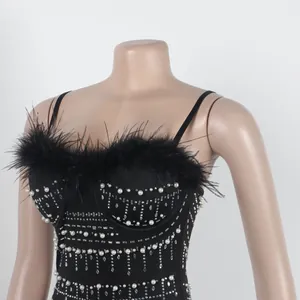 Λεπτομέρεια μαύρου bodycon φορέματος με πούπουλα στρουθοκαμήλου και μαργαριταρένια στρας.