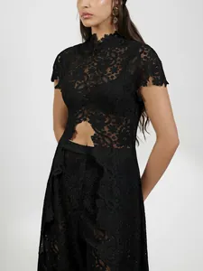 Detailed view of elegant black lace dress with hollow-out floral pattern and slit