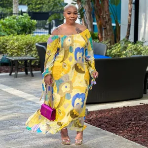 Full body view of a vibrant yellow floral off-the-shoulder maxi dress in a garden setting