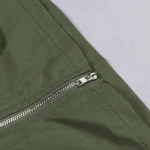 High-quality detailed macro view of metal zipper on olive green cargo skirt fabric