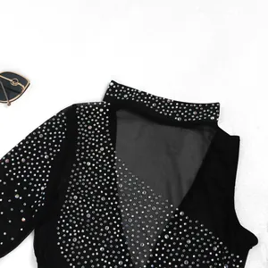 Primer plano de brillantes pedrería sobre tela de malla negra de un vestido sexy.