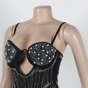 Close-up of black bodycon dress featuring pearl and rhinestone embellishments on corset.