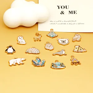 Collection of diverse winter-themed enamel pendants on a warm yellow background.