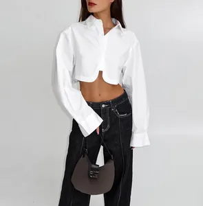 Modella indossa una camicia bianca corta stile francese con maniche lunghe e orlo curvo.