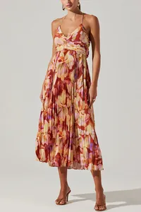 Model wearing a vibrant V-neck floral pleated halter midi dress in a minimalist studio