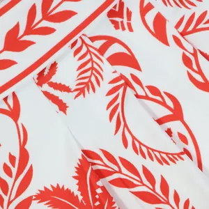 Vue détaillée de l'imprimé feuilles rouges sur le tissu blanc doux de cette combi-pantalon