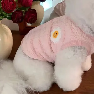 Gros plan d'un gilet en polaire rose pour animal avec un patch fleur souriante.