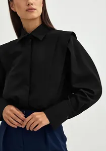 Elegant black cotton blouse featuring structured shoulder details and long sleeves for women.