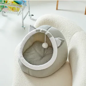 Detalle de cama para gatos gris semicerrada con pompón de peluche en un sofá