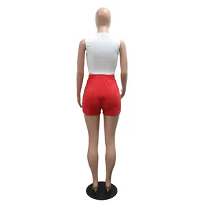 Achteraanzicht van tweedelige set met witte mouwloze crop top en rode korte broek