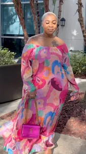 Model wearing a vibrant off-the-shoulder floral print maxi dress in an outdoor setting