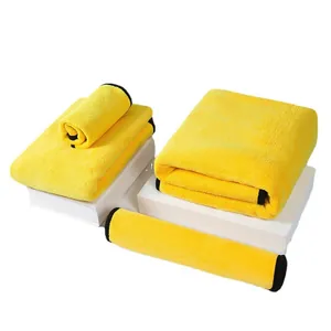 Un ensemble de serviettes en microfibre jaune pour animaux pliées sur des socles blancs