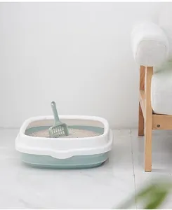 Detail view of semi-enclosed green and white cat litter box in a clean home setting.
