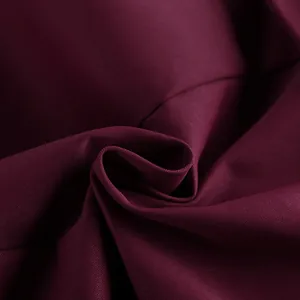 Dettaglio ravvicinato del tessuto bordeaux premium per tailleur con trama e morbido drappeggio