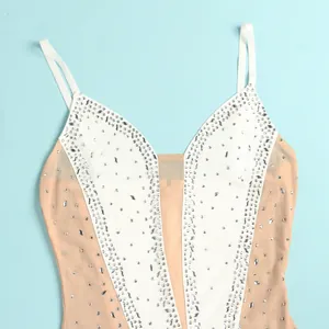 Close-up of sparkling silver rhinestones on a nude mesh and white panel bodysuit