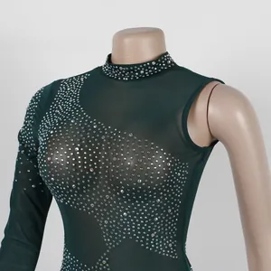 Detalle de cerca de un vestido de malla verde oscuro con brillantes de pedrería.
